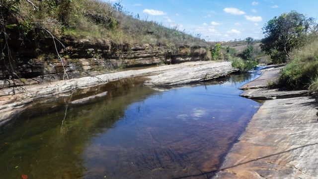 Seguindo o curso da água tem uma pequena cachoeira e vários poços